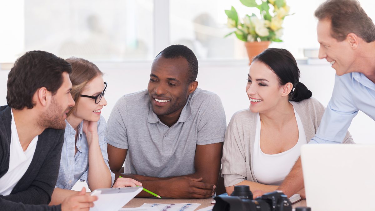 equipe de marketing em uma reunião conversando e sorrindo, trabalhando com alegria e entusiasmo.