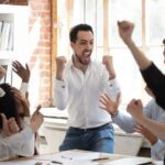 Equipe vibrando os resultados atingidos e comemorando vitórias no ambiente de trabalho