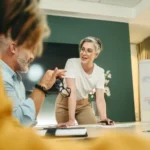 Líder mentor(a) e equipe de marketing discutindo estratégias para campanha de um novo produto