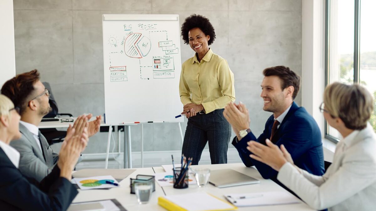 Líder conduz reunião colaborativa com uma equipe diversa em ambiente corporativo moderno, representando a influência da liderança na construção da cultura organizacional.