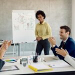 Líder conduz reunião colaborativa com uma equipe diversa em ambiente corporativo moderno, representando a influência da liderança na construção da cultura organizacional.
