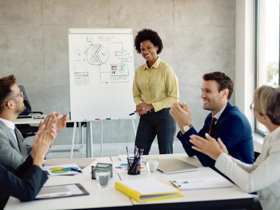 Líder conduz reunião colaborativa com uma equipe diversa em ambiente corporativo moderno, representando a influência da liderança na construção da cultura organizacional.