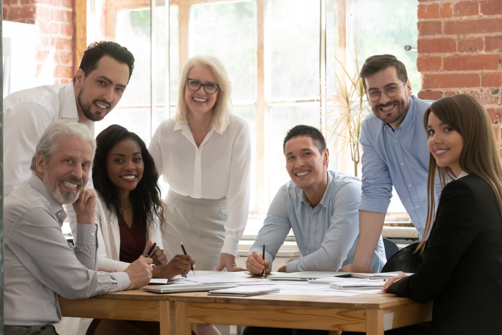 Profissionais de diferentes gerações conversando em reunião de trabalho